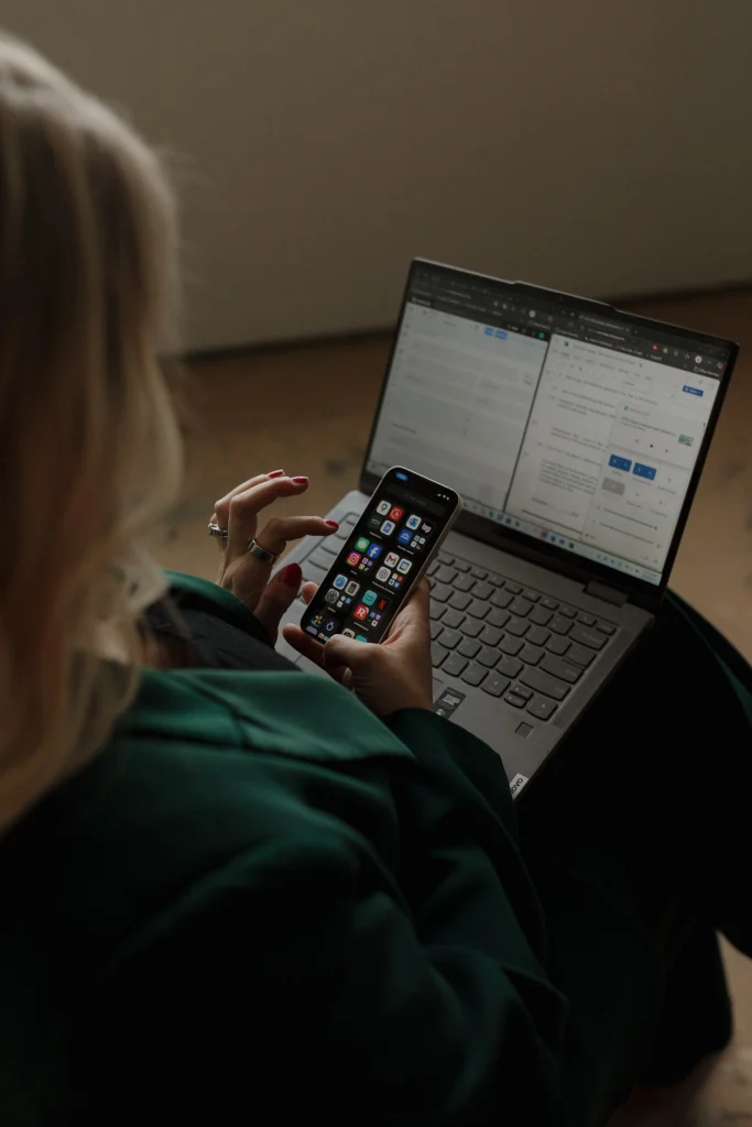 Person scrolling through her messages while working on the laptop for emro law